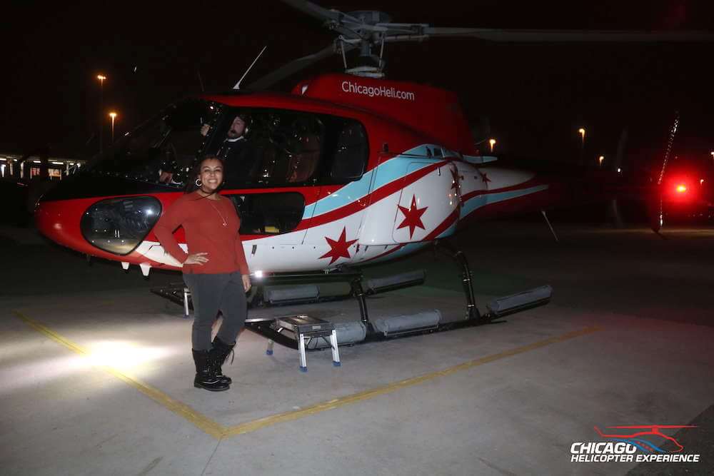 Woman outside of small helicopter at night
