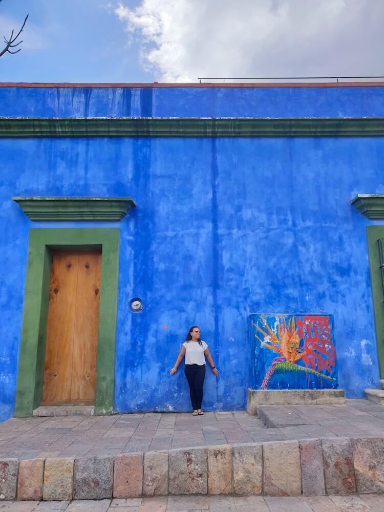 Woman against a blue wall in Oaxaca, Mexico